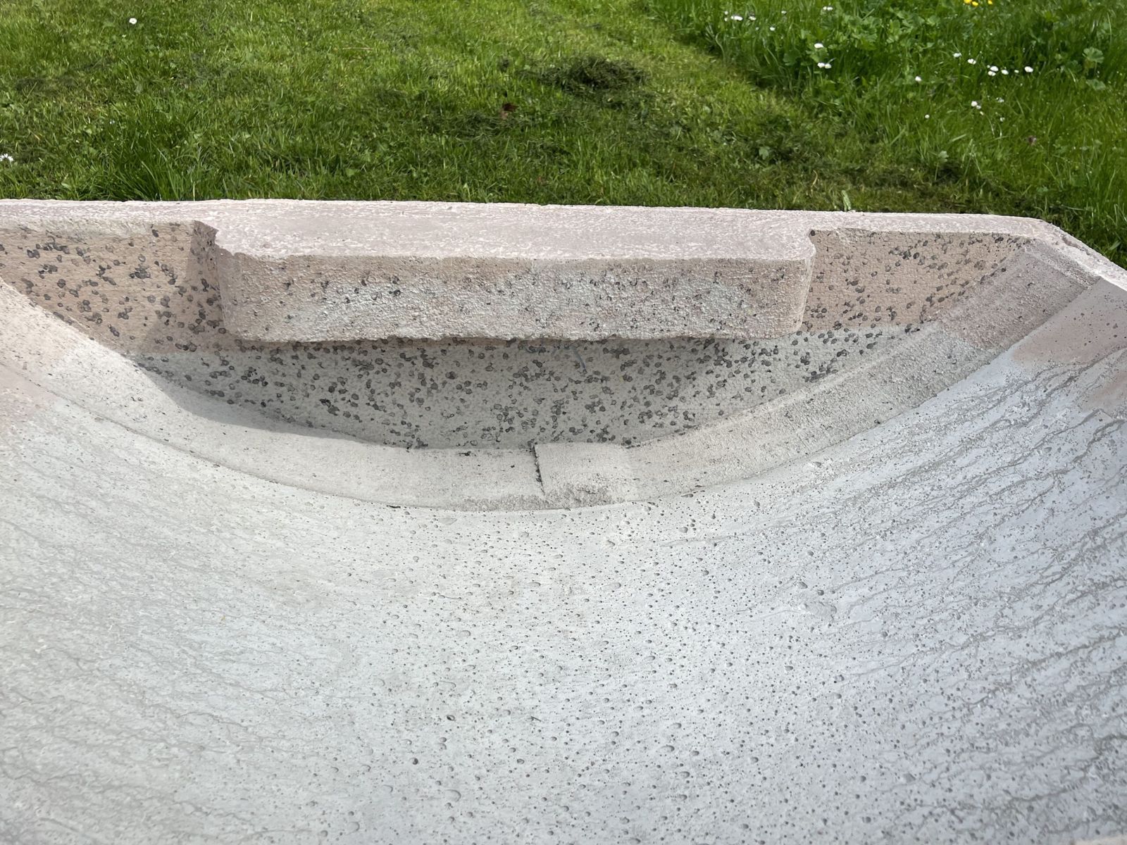 Nahaufnahme des eingegossenen Verstecks: eine Betonplatte ragt über die Beckenwand und bildet darunter einen Hohlraum